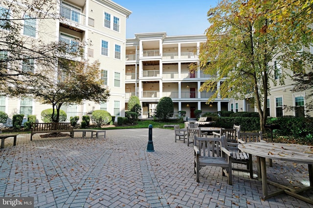 surrounding community featuring outdoor dining space and a patio