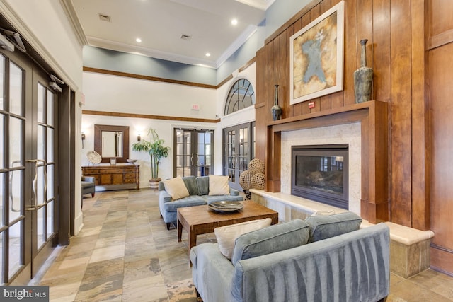 living area featuring french doors, a fireplace, visible vents, and crown molding