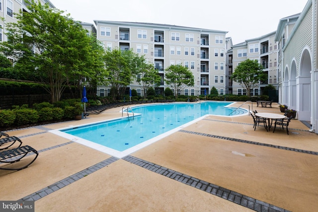 pool featuring fence and a patio