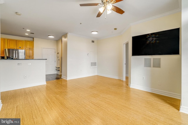 unfurnished living room with crown molding, light wood finished floors, visible vents, and baseboards