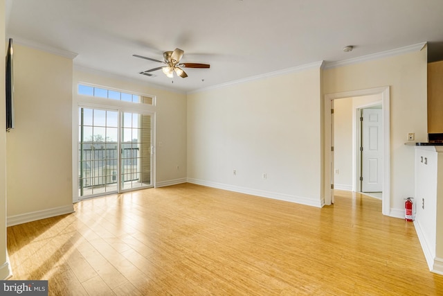 empty room with crown molding, visible vents, light wood-style flooring, ceiling fan, and baseboards