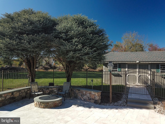 view of patio with a storage shed and a fire pit