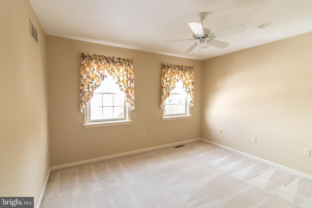 empty room with ceiling fan and light carpet