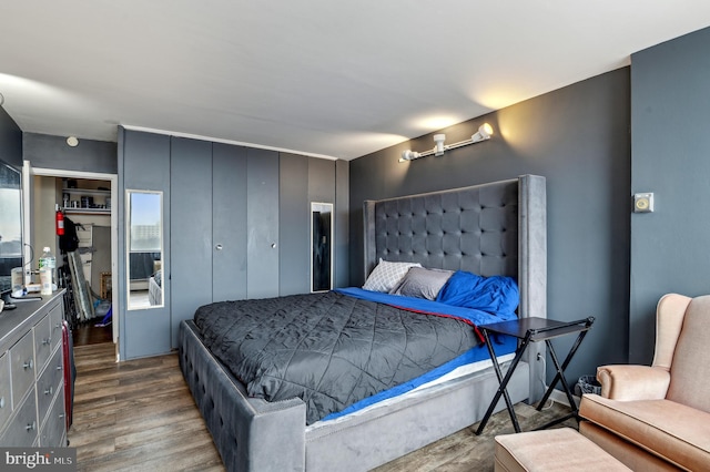 bedroom with dark hardwood / wood-style flooring and a closet