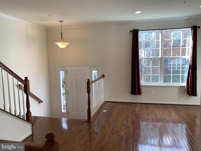 foyer entrance with plenty of natural light, dark hardwood / wood-style flooring, and crown molding