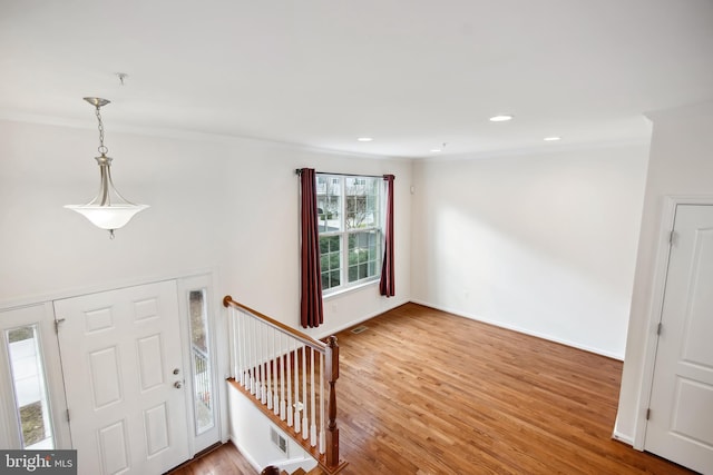 entryway featuring hardwood / wood-style flooring and crown molding