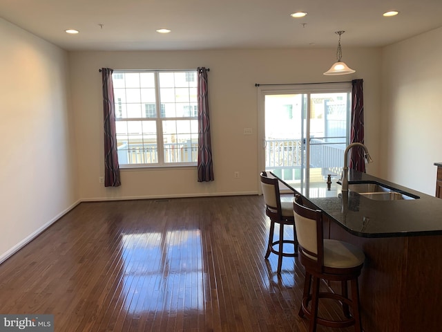 dining area with dark hardwood / wood-style floors, a healthy amount of sunlight, and sink