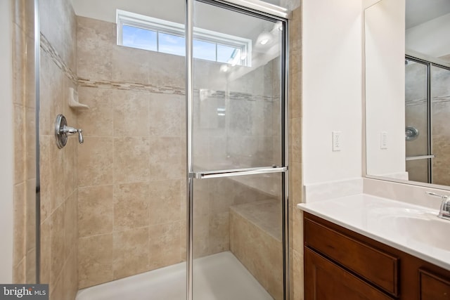 bathroom featuring vanity and a shower with door