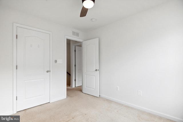 unfurnished bedroom featuring light colored carpet and ceiling fan