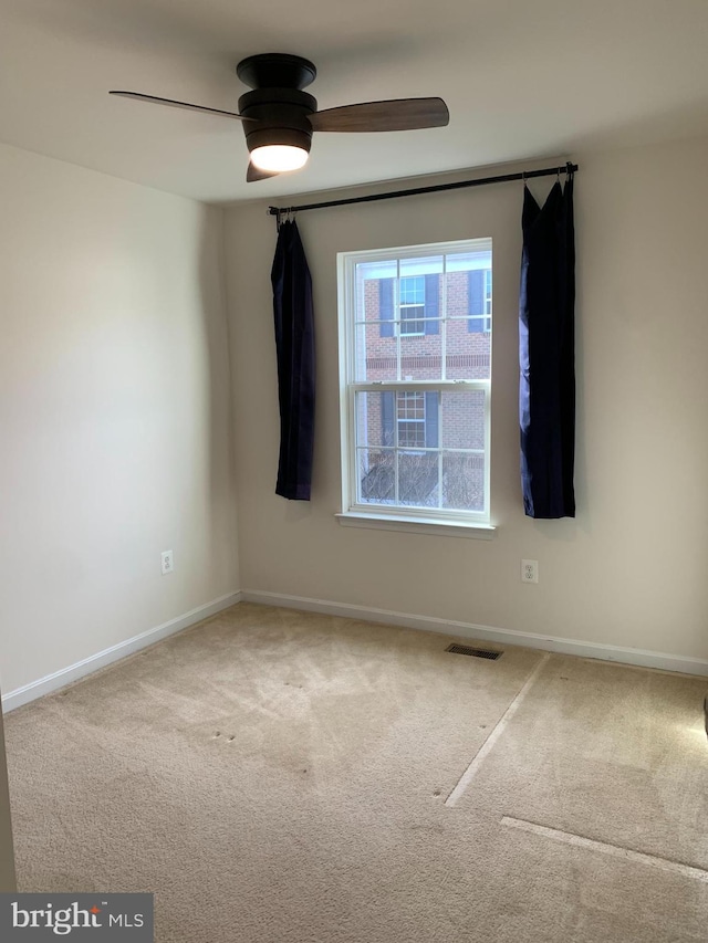 carpeted spare room featuring ceiling fan