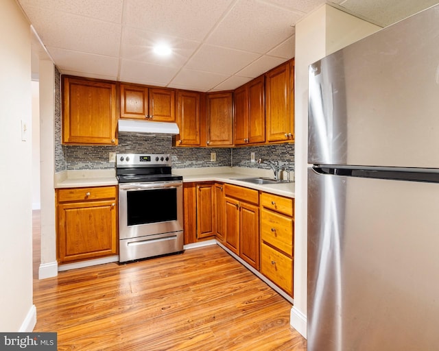 kitchen featuring decorative backsplash, sink, stainless steel appliances, and light hardwood / wood-style flooring