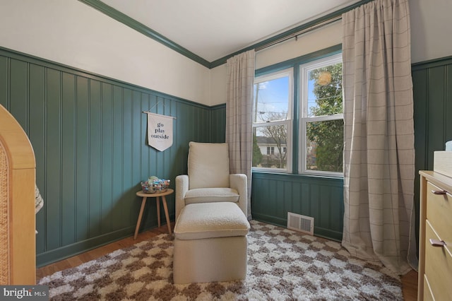 living area featuring hardwood / wood-style floors and ornamental molding