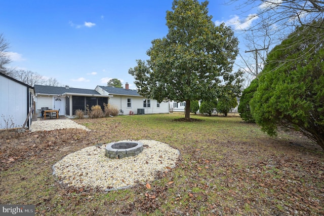 view of yard with cooling unit and an outdoor fire pit