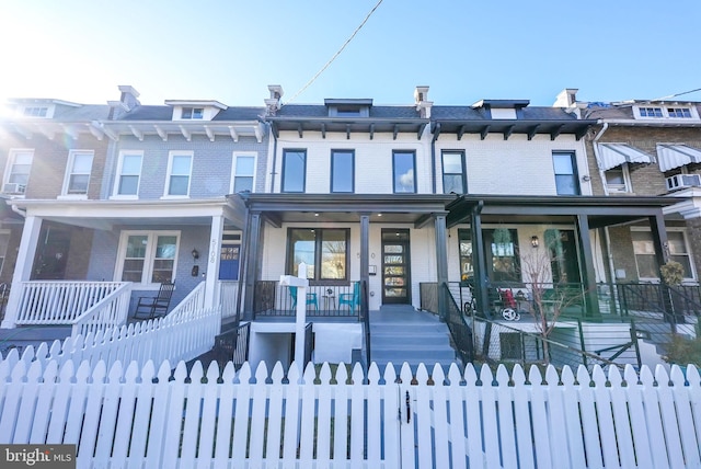 townhome / multi-family property with covered porch and cooling unit