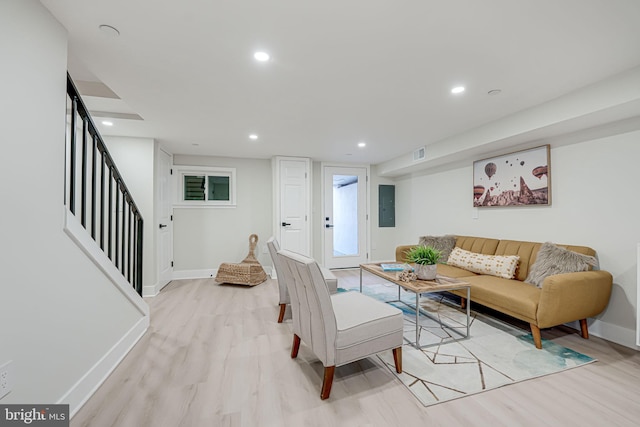 living room with electric panel and light hardwood / wood-style flooring