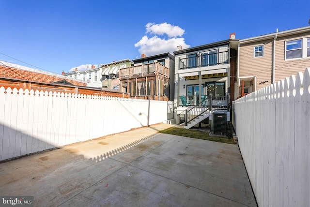 back of property with cooling unit and a patio area