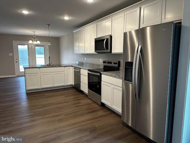 kitchen with kitchen peninsula, stainless steel appliances, white cabinets, and hanging light fixtures