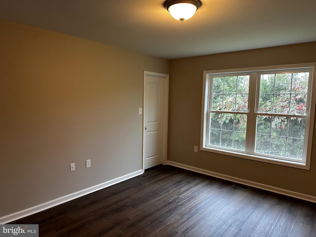 spare room featuring dark wood-type flooring