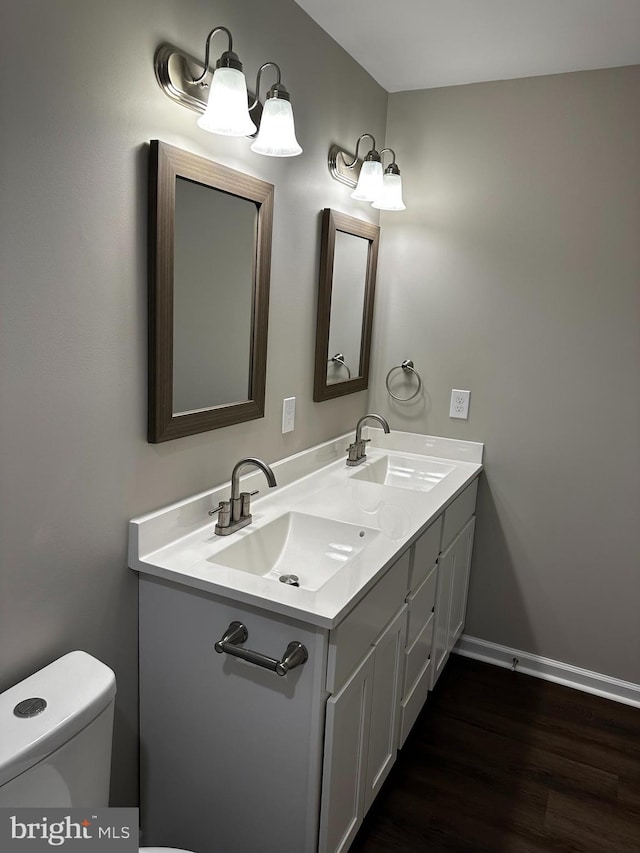 bathroom featuring vanity, wood-type flooring, and toilet