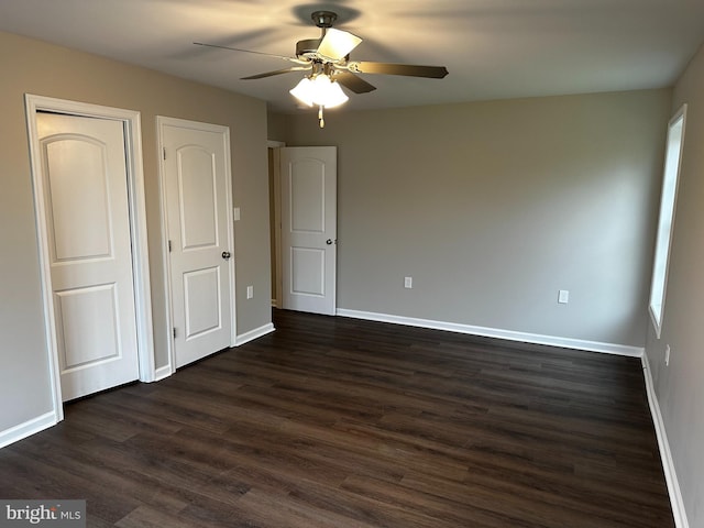 unfurnished bedroom featuring ceiling fan and dark hardwood / wood-style flooring