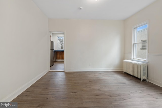 spare room featuring hardwood / wood-style flooring and radiator heating unit