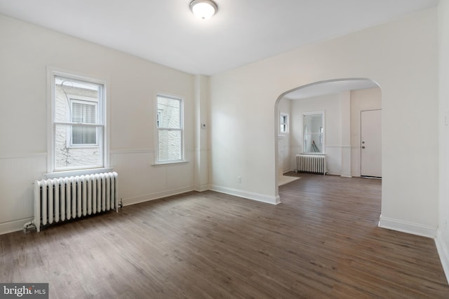 empty room with radiator and dark hardwood / wood-style floors