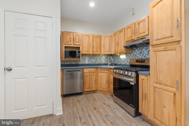 kitchen featuring light brown cabinetry, tasteful backsplash, stainless steel appliances, sink, and light hardwood / wood-style flooring