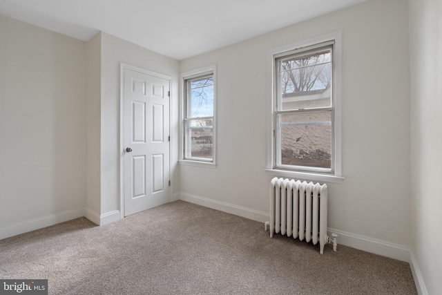 spare room featuring radiator heating unit and carpet floors