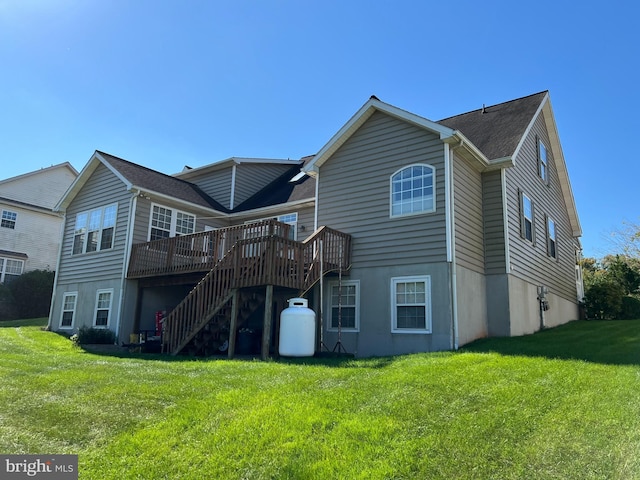 rear view of house with a lawn and a wooden deck