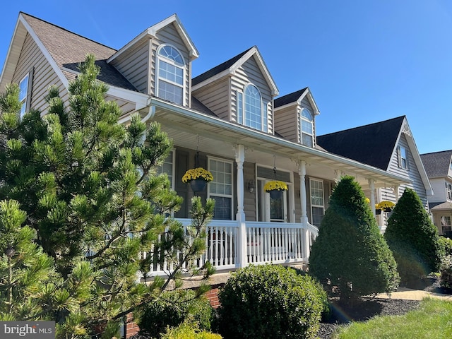 cape cod home featuring a porch