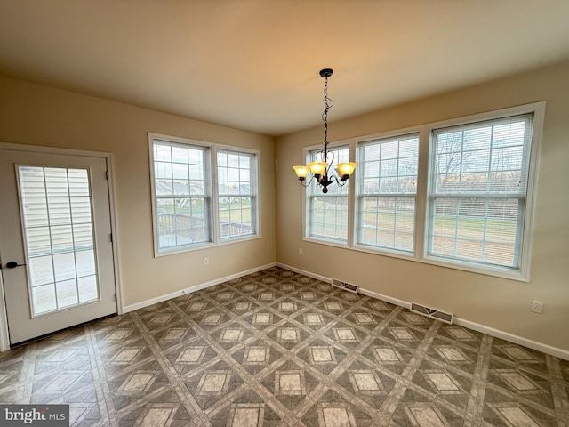 unfurnished dining area with parquet flooring and an inviting chandelier