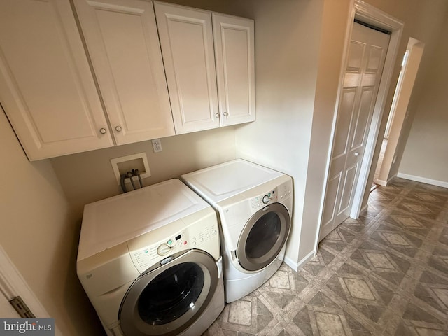 washroom with washer and dryer and cabinets