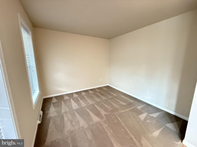 unfurnished room featuring carpet floors and a baseboard heating unit