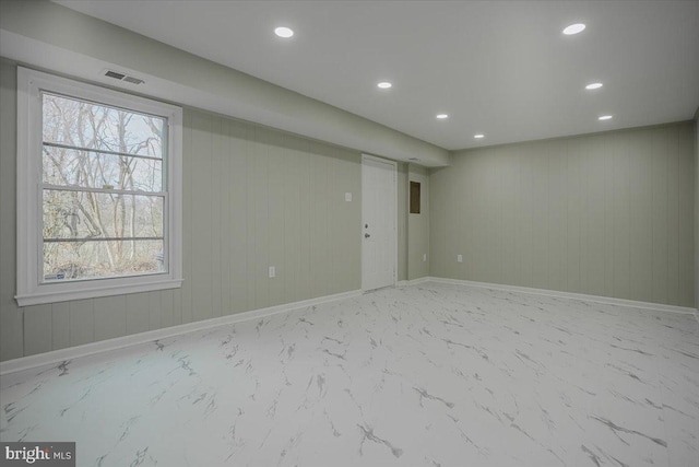 basement featuring wooden walls