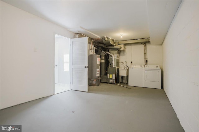 basement with gas water heater, independent washer and dryer, sink, and heating unit