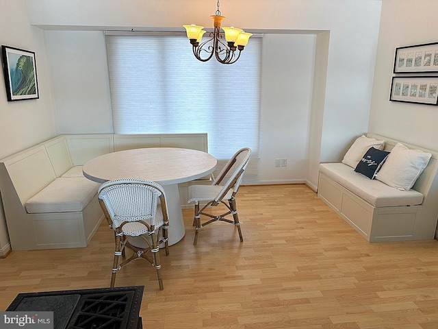 dining room with breakfast area, an inviting chandelier, and light hardwood / wood-style flooring