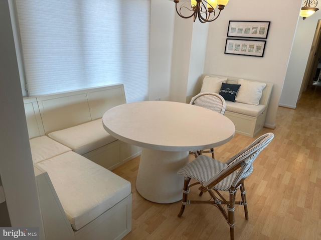 dining space featuring an inviting chandelier and light hardwood / wood-style flooring