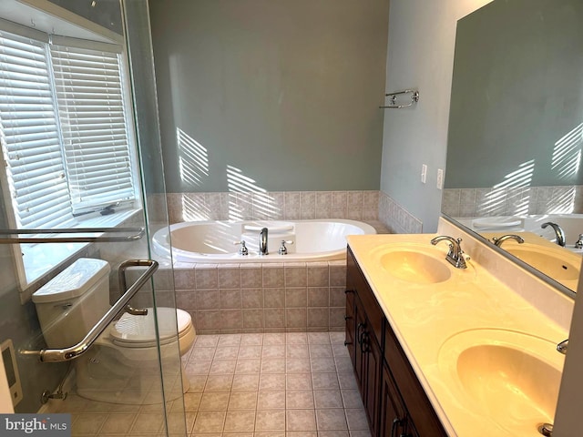 bathroom featuring tile patterned floors, vanity, toilet, and tiled tub