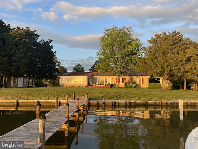 dock area featuring a water view and a lawn