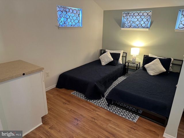 bedroom featuring lofted ceiling and hardwood / wood-style floors