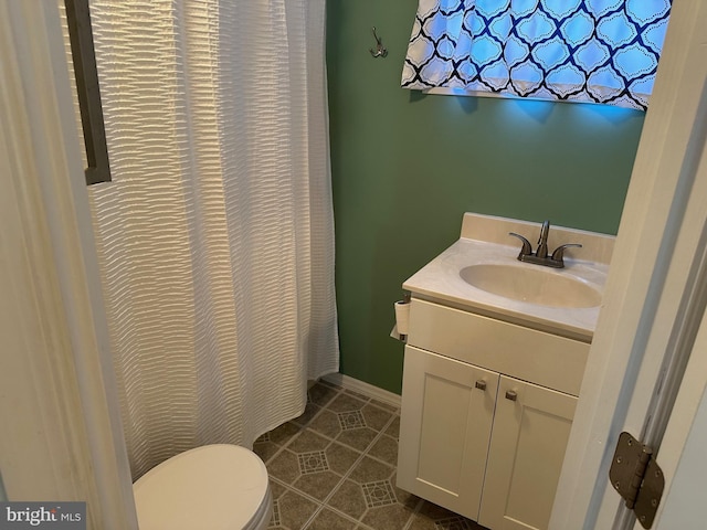 bathroom featuring vanity, tile patterned floors, and toilet