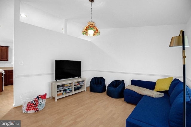 living room featuring vaulted ceiling and light wood-type flooring