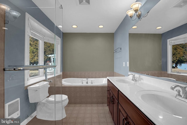 bathroom featuring heating unit, tile patterned flooring, vanity, a relaxing tiled tub, and toilet