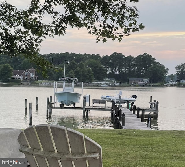 view of dock featuring a water view and a lawn