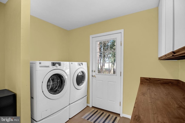 laundry area featuring cabinets and washer and clothes dryer