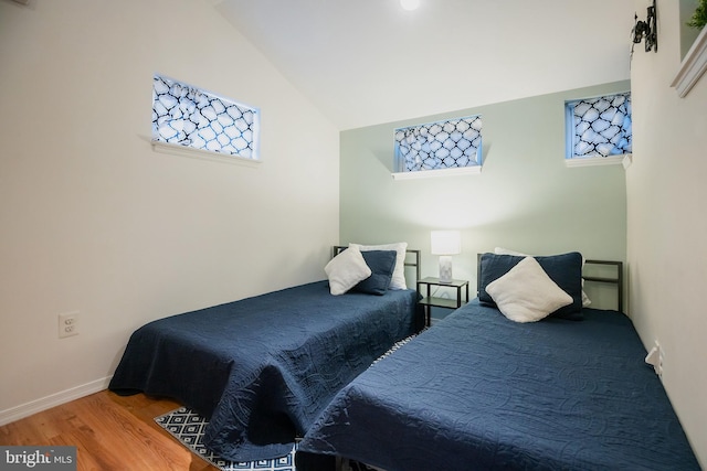 bedroom with vaulted ceiling and wood-type flooring