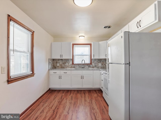 kitchen with backsplash, white appliances, sink, and white cabinets