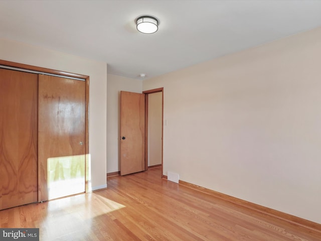 unfurnished bedroom featuring light wood-type flooring and a closet