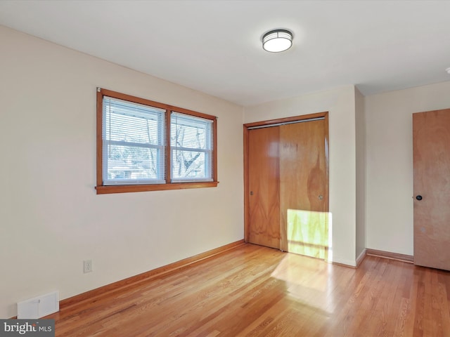 unfurnished bedroom with a closet and light hardwood / wood-style flooring