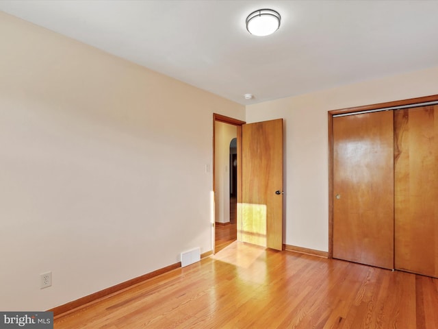 unfurnished bedroom with light hardwood / wood-style floors and a closet